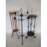 A floor standing wrought iron 7 branch candelabra along with a wrought iron plant stand and a wooden