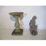 A weathered concrete statue of a seated woman (64cm H) along with a pedestal birdbath marked "2000
