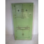 A green painted vintage kitchen cabinet with drop down enamelled surface, one drawer and two