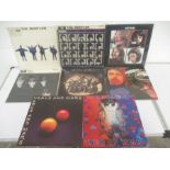 A collection of four Beatles 12" vinyl records including Help!, A Hard Day's Night, Let It Be & With
