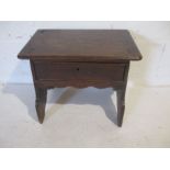 An antique oak stool with single drawer