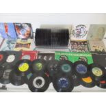 A collection of 7" vinyl records including The Beatles, Rod Stewart, Genesis, Paul McCartney,