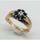 A 9 ct gold ring set with sapphires and a central diamond chip, weight 2.5g