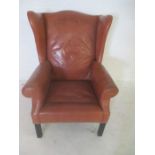 A leather style wingback armchair.