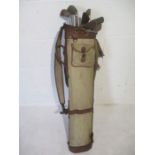 A set of Hickory shafted antique golf clubs with a bag.