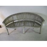 A weathered wooden curved garden bench, width 160cm