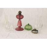 An antique glass oil lamp, green shade and various other accoutrements