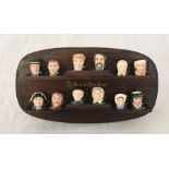 A collection of Royal Doulton miniature Toby jugs on branded display stand all in the form of