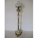 An adjustable floor standing pottery and brass oil lamp with claw feet, the pottery sections