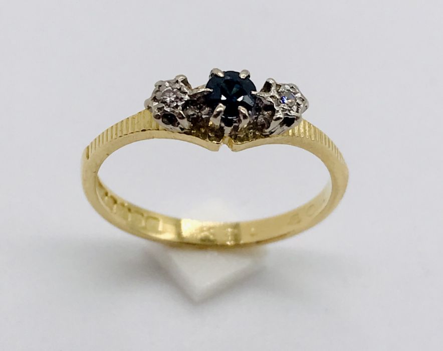 A diamond and sapphire three stone ring set in 18ct gold