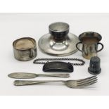 A hallmarked silver inkwell, small silver three handled trophy, silver serviette ring etc.