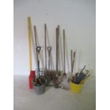 A collection of various tools including shovels, sledgehammers, chains, hand tools etc.