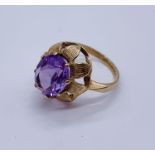 An unmarked 9ct gold ring set with amethyst