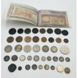 A collection of various coins with some silver along with an album of worldwide banknotes, coins