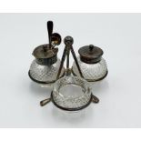A silver plated condiment set on golf club supports with golf ball finial