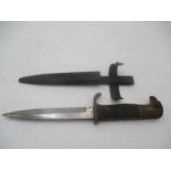 A German WWII dagger with eagle head handle over black chequered grip in metal scabbard