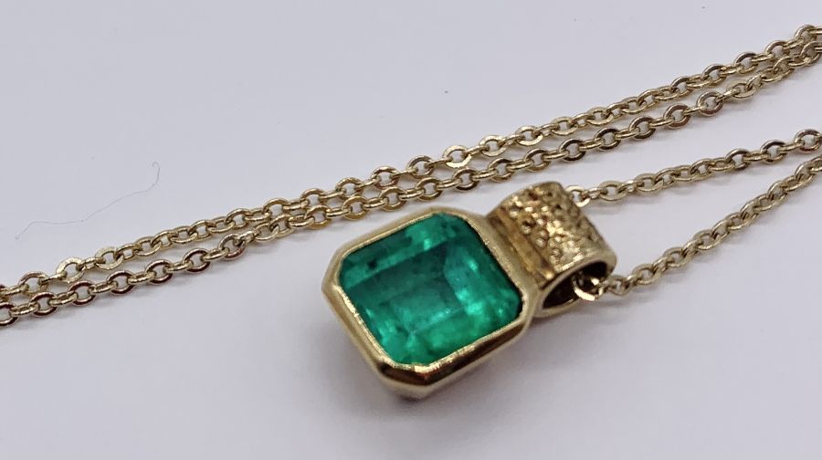 An emerald ( approx 7 mm x 6 mm) set in unmarked gold pendant on a 14 ct gold fine chain, total - Image 2 of 2