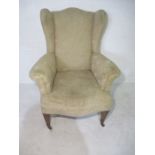 A wing back armchair, stamped J. Brewer to underside.
