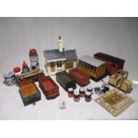 A collection of garden railway including a coach, several wagons, station building, spare parts