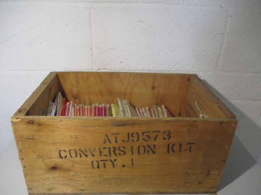 A collection of ordnance survey maps in a wooden crate. Areas covered include Norfolk, Ely, West