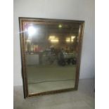 A gilt and black framed mirror. 113cm x 88cm