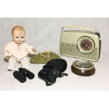 An assortment of items including a German doll, Bush TR 820 radio, barometer etc.