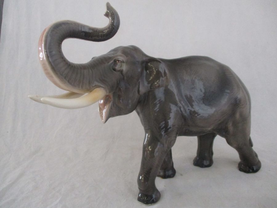 A ceramic elephant. Height 41cm. Has had a repair to one tusk. AF