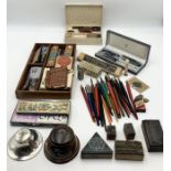 A collection of various writing paraphernalia including vintage printing stamps, vintage pencil