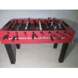 A Coca-Cola branded table football game, including five balls. One side faded by Sun.