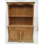 A miniature pine dresser with two cupboards under. Height 55cm, Width 37cm.