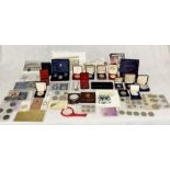 A collection of assorted commemorative coins, notes, and ephemera