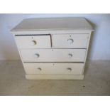 A white painted pine chest of four drawers