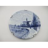 A Dutch Delft blue and white wall hanging plaque of a windmill scene by F.J. Du Chattel - diameter