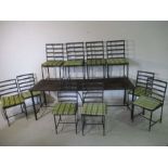 A large rustic metal garden table with ten matching chairs