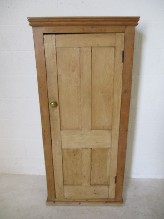 A pine panelled cupboard with single door