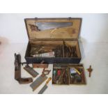 A vintage tool chest with a large selection of various tools including hammers, saws, wooden planes,