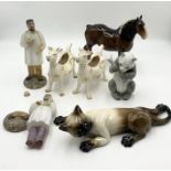 A collection of various ornaments including two Beswick green label milk jugs in the form of cows, a