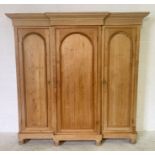 A pine triple wardrobe in three separate sections with hanging rails and drawers and shown -