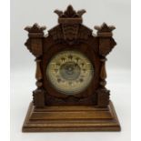 A wooden carved mantle clock made by the Ansonia Clock Company New York