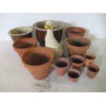 A collection of terracotta flower pots along with two glazed pots and a painted concrete duck