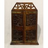 A small carved corner unit with lattice top, brass edgings and two shelves inside