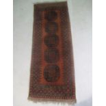 A hand woven Eastern red ground runner, 244cm x 58cm