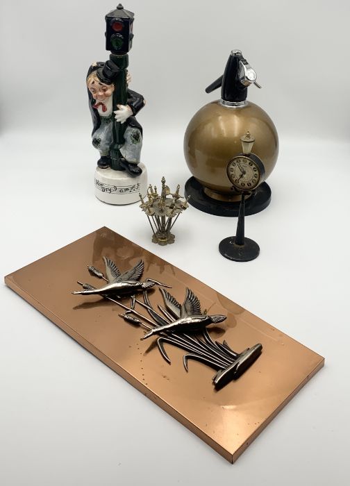 A collection of various items including West German copper wall plaque, vintage soda siphon, novelty