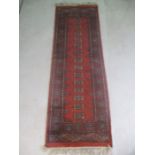A 20th Century Eastern red ground runner, approx 190cm x 64cm