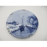 A Dutch Delft blue and white wall hanging plaque of canal scene by Louis Apol - diameter 35cm