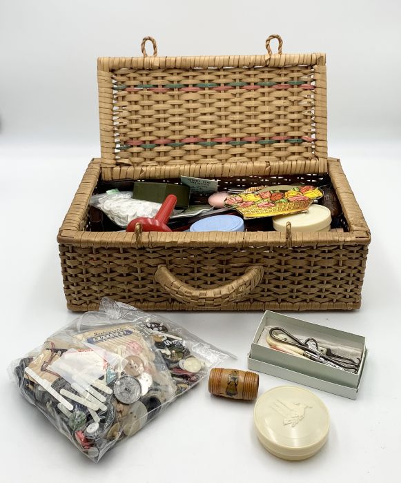 A wicker basket containing a quantity of sewing related items, books, buttons etc.