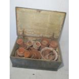 A vintage wooden trunk with an assortment of terracotta pots.