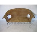 A rattan two seater sofa with metal detailing