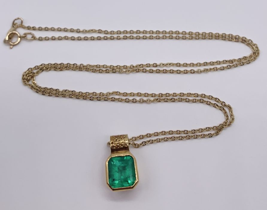 An emerald ( approx 7 mm x 6 mm) set in unmarked gold pendant on a 14 ct gold fine chain, total