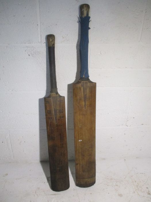 Two vintage cricket bats one is marked Nicolls and stamped J F Anderson, the other is a Gradidge,